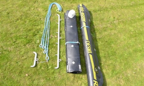 DESMI RO-BOOM components with ropes and tools laid on grass.