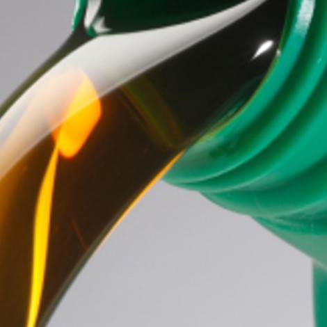 Złota ciecz wlewana z zielonego plastikowego pojemnika.