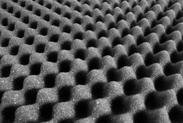 Gros plan de mousse alvéolée noire avec un motif texturé en forme de vagues.