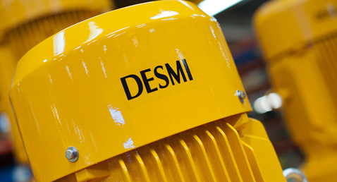 Yellow DESMI industrial motor, close-up view, highlighting brand logo.