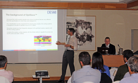 Presentation on OptiSave by DESMI, with attendees listening attentively in a conference room.