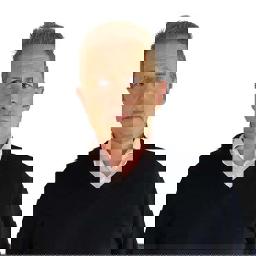 Man in a black sweater and white shirt against a white background.