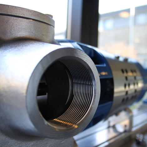 Nærbilde av en DESMI industriell pumpe for væskehåndtering i et verksted.